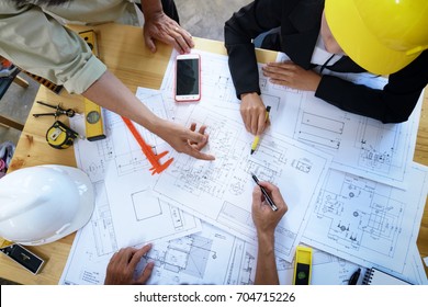 Engineer People Meeting Working And Pointing At A Drawings In Office For Discussing. Engineering Tools And Construction Concept.