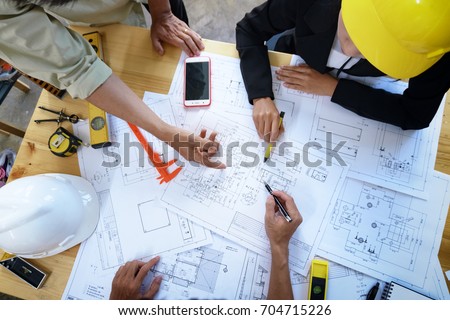 engineer people meeting working and pointing at a drawings in office for discussing. Engineering tools and construction concept.
