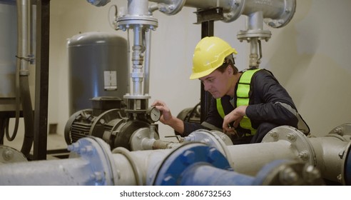 An engineer performs a diagnostic check on an industrial pump system, carefully monitoring the pressure gauge to ensure operational safety and efficiency.