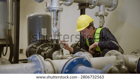 An engineer performs a diagnostic check on an industrial pump system, carefully monitoring the pressure gauge to ensure operational safety and efficiency.