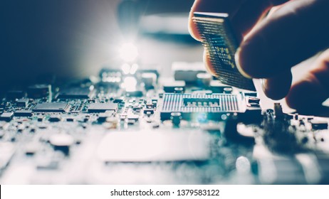 Engineer Plugging CPU Microprocessor To Motherboard Socket. Computer Technology And Hardware Maintenance Or Repair.