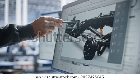 Engineer Points Pen at Display to Analyze 3D Car Frame Tolerances and Structural Specs. Rigorous Research Ensures High Quality Vehicle Production Lines. Quality Inspection, Structural Analysis.