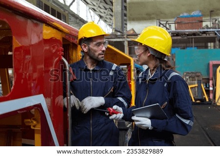 Engineer in the process of inspecting train engines Keep the machine ready for use in the train station. Engineers wear safety clothing and helmets to work safely as standard.