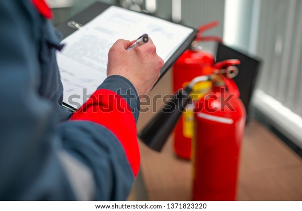Engineer\
Professional are Checking A Fire Extinguisher Using Clipboard or\
checking Industrial fire control system,Fire Alarm controller, Fire\
notifier.System ready In the event of a\
fire.