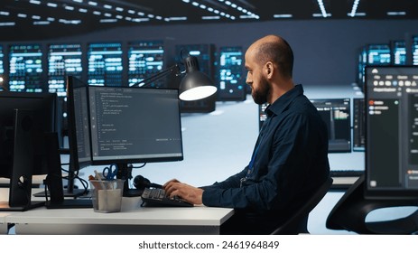 IT engineer programming in server hub housing advanced equipment storing massive datasets. Technician typing code on computer to mend data center racks doing complex computational operations