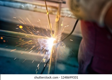 Engineer in protective uniform working with specialized machines in production industry, taking care of the gears, electronic parts and sustainability of machinery.