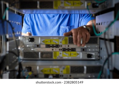IT Engineer is pulling the server out out of the cabinet in the data center - Powered by Shutterstock - Get 15% off with code: PIKWIZARD15