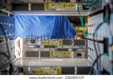 IT Engineer is pulling the server out out of the cabinet in the data center
