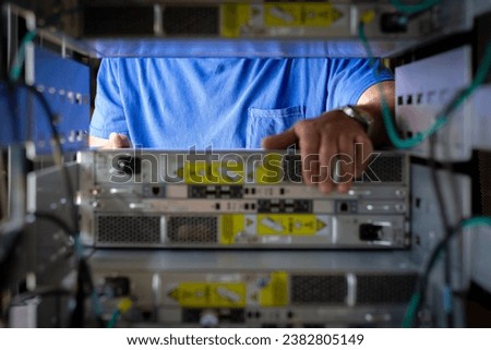 IT Engineer is pulling the server out out of the cabinet in the data center