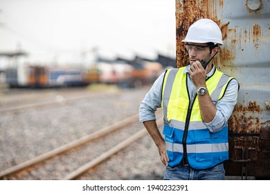 Engineer railway checking construction process train and railroad station .Engineer wearing safety uniform and helmet by using walki-talkie in work.