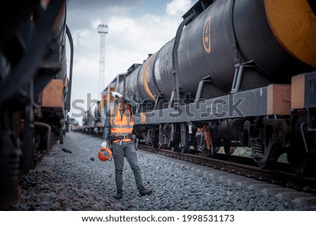Engineer railway posing tried from work inspection train testing and checking railway work on railroad station with radio communication .Engineer wearing safety uniform and safety helmet in work.