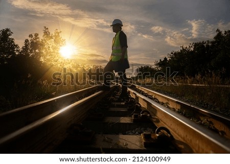 Engineer railway under  checking construction process train testing and checking railway work on railroad station with radio communication .Engineer wearing safety uniform and safety helmet in work.