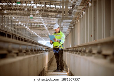 Engineer railway under inspection and checking construction process train work shop and railroad station .Engineer wearing safety uniform and helmet by holding document in work.