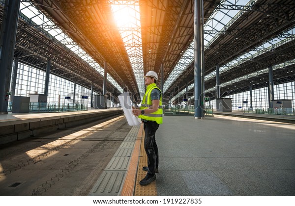 Engineer railway under\
inspection and checking construction process railway and checking\
work on railroad station .Engineer wearing safety uniform and\
safety helmet in work.