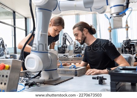 An engineer in research development robotic factory checking prototype of automation robot arm