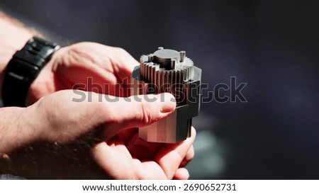 Engineer rotating complex metal part in hands. Media