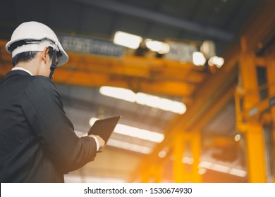 Engineer in safety helmet finger gesture scrolling in touchpad while searching for technical data at Industry Manufacturing Factory. Maintenance engineer using digital tablet control, inspect Project - Powered by Shutterstock