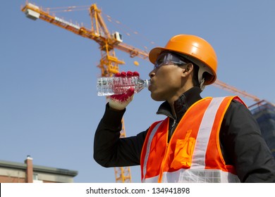 Engineer With Safety Vest Drinking Water Under Construction