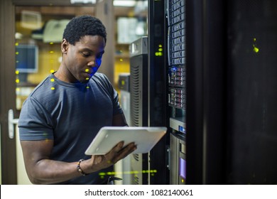 Engineer in the server room checking tablet