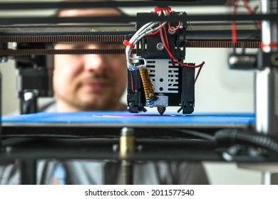 An engineer is setting up a machine for 3D printing, a printer for volumetric printing of parts. 