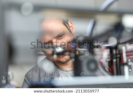 An engineer is setting up a machine for 3D printing, a printer for volumetric printing of parts. 