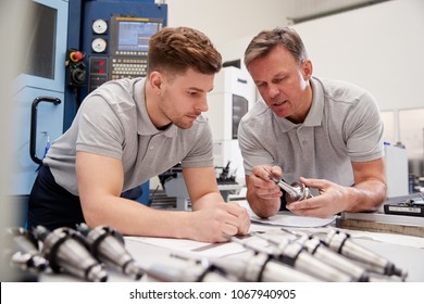 Engineer Showing Apprentice How To Measure CAD Drawings