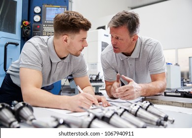 Engineer Showing Apprentice How To Measure CAD Drawings