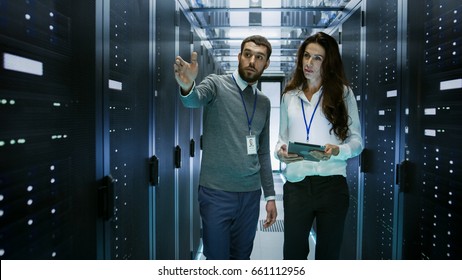 IT Engineer Shows Working Data Center / Server Room to Female Chief Engineer who Holds Tablet Computer.