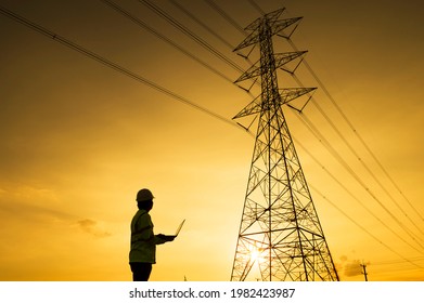 Engineer Silhouette Standing At Power Station Planning Work On Power Generation At High Voltage Electrodes.