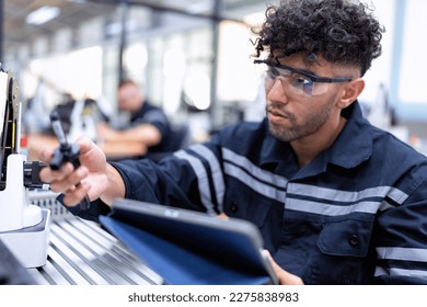 Engineer sitting in robot fab. room use tablet pc quality check robot arm hardware engineering