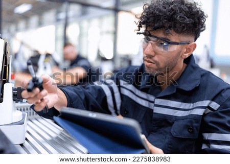 Engineer sitting in robot fab. room use tablet pc quality check robot arm hardware engineering
