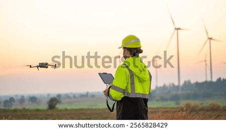Engineer Specialists Pilot Drone on Wind Turbine Farm. Architectural Engineer and Safety Engineering Inspector Fly Drone at industrial plant.