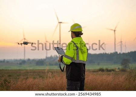 Engineer Specialists Pilot Drone on Wind Turbine Farm. Architectural Engineer and Safety Engineering Inspector Fly Drone at industrial plant.
