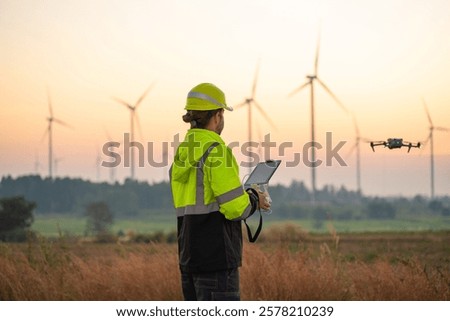 Engineer Specialists Pilot Drone on Wind Turbine Farm. Architectural Engineer and Safety Engineering Inspector Fly Drone at industrial plant.