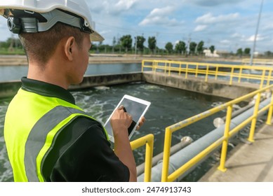 an engineer stand aside at the waste water pool and check the list on tablet to make sure that the gauge at standard value, waste water treatment