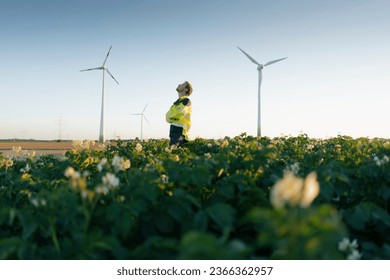 Engineer standing in a field at a wind farm Stock Photo