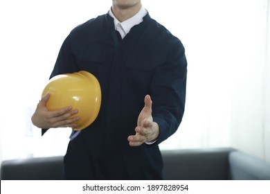 Engineer standing with hardhat in office
