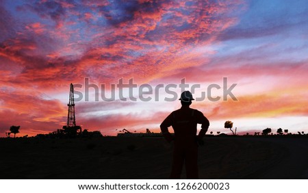 An engineer is standing in the Oilfield during sunset in the Oman 