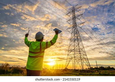 Engineer succeeded after checking at the power station for planning work by generating electricity from the high-voltage transmission tower at sunset.