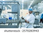 Engineer supervising the food production process in a high tech manufacturing plant inspecting conveyor systems for quality assurance showcasing modern technology in industrial processes.