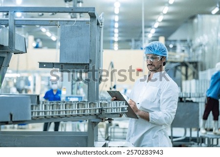 Engineer supervising the food production process in a high tech manufacturing plant inspecting conveyor systems for quality assurance showcasing modern technology in industrial processes.