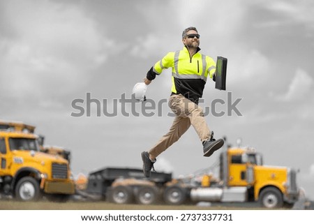 Engineer supervisor running outdoor. Supervisor jumping. Good job. Happy construction builder. Worker jumping at heavy machines. Man engineer running to success. Builder man run to work