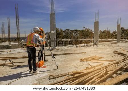 Engineer and surveyor worker working with theodolite transit equipment at outdoors construction site