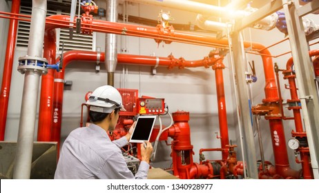 Engineer With Tablet Check Red Generator Pump For Water Sprinkler Piping And Fire Alarm Control System.