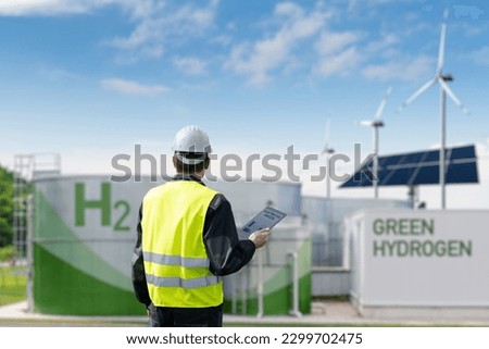 Engineer with tablet computer on a background of Green Hydrogen factory