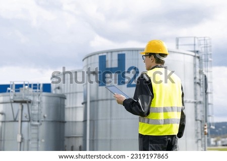 Engineer with tablet computer on a background of Hydrogen factory	