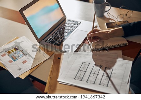 Engineer taking notes with a pencil at the desk