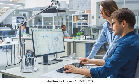 Engineer Talking With Project Manager and Working on Desktop Computer Using CAD Software with Technical Drawings on the Screen. In the Background Engineering Facility Specialising on Industrial Design - Shutterstock ID 1515843710