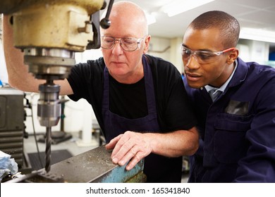 Engineer Teaching Apprentice To Use Milling Machine