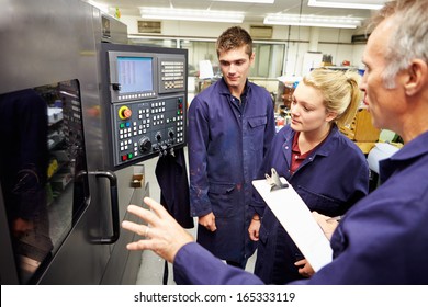 Engineer Teaching Apprentices To Use Computerized Lathe - Powered by Shutterstock